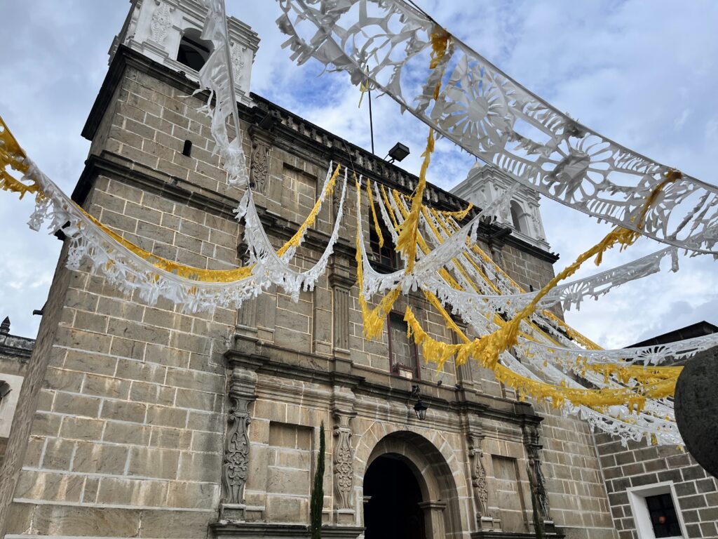 An old stone church draped in yellow and white streamers.